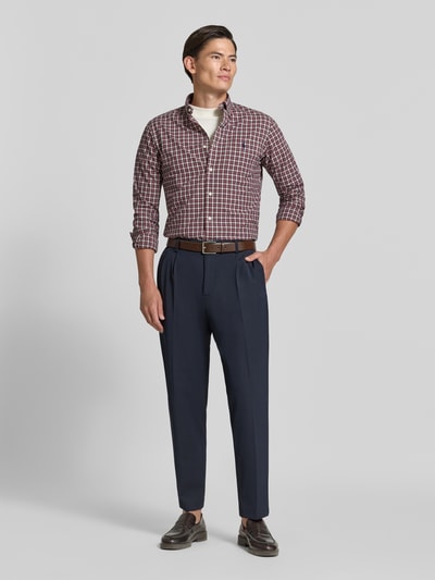 Männermodel trägt Custom Fit Freizeithemd aus reiner Baumwolle von Polo Ralph Lauren, karierte Muster in Rot und Blau, Ganzkörperansicht von vorne.