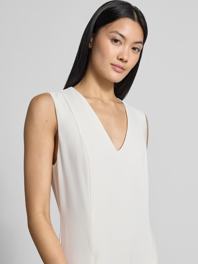 Frauenmodel trägt Regular Fit Midikleid mit Kellerfalten Modell 'Carneli' von Ted Baker in Creme, V-Ausschnitt, ärmellos, Nahaufnahme Oberkörper. Damen Midikleid von Ted Baker, Kellerfalten, Rückenlänge 122 cm, Brustweite 45 cm, ärmelloses Design.