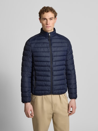 Männermodel trägt dunkelblaue 'Steppjacke mit Reißverschluss' von MCNEAL, Regular Fit, Stehkragen, Reißverschlusstaschen, Ganzkörperansicht von vorne.