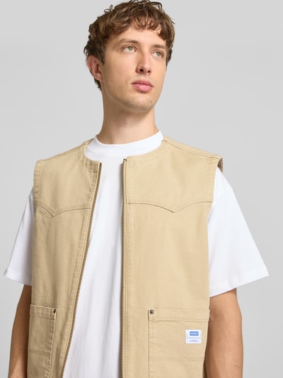 Männermodel trägt Regular Fit Weste aus Baumwoll-Mix Modell 'BRIDGELEY263W1' von Hugo Blue in Beige, Nahaufnahme Oberkörper.