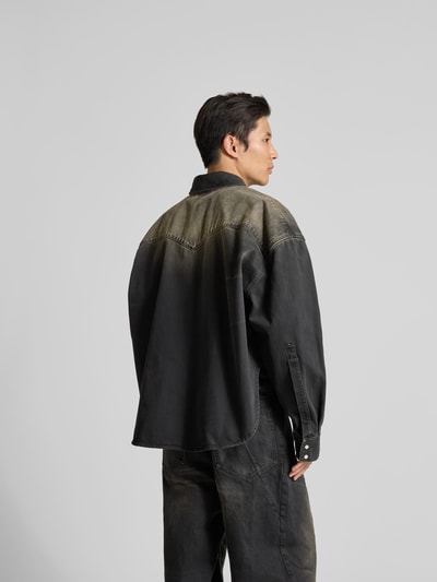 Männermodel trägt Relaxed Fit Jeanshemd im Used-Look von VETEMENTS in Schwarz mit Brusttaschen, Reine Baumwolle, Ganzkörperansicht Rückansicht. Rückenlänge 74 cm, Schulterbreite 50 cm, Ärmellänge 74 cm.