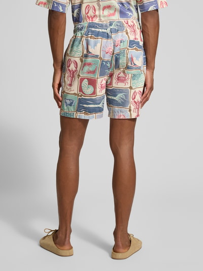 Männermodel trägt Shorts aus reiner Baumwolle von Gant, gemusterte Farben, gerader Schnitt, elastischer Bund, Ganzkörperansicht Rückansicht.