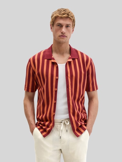 Männermodel trägt Regular Fit Freizeithemd aus reiner Baumwolle von Marc O'Polo, gestreift in Rot-Orange, Strickoptik, Nahaufnahme Oberkörper.