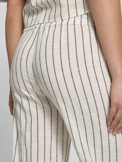 Frauenmodel trägt Losse Fit Stoffhose aus reiner Baumwolle Modell 'TIZIANA' von Only mit gestreiftem Allover-Muster, elastischem Bund und seitlichen Eingrifftaschen, helle Farben, feine Linienstruktur, Nahaufnahme Hüfte und Oberschenkel, Detailaufnahme.