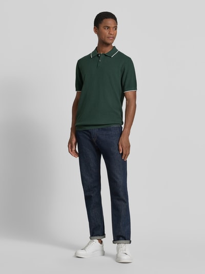 Männermodel trägt Regular Fit Poloshirt mit Kontrastkante von Christian Berg Men, Reine Baumwolle, Strukturmuster, Ganzkörperansicht von vorne.