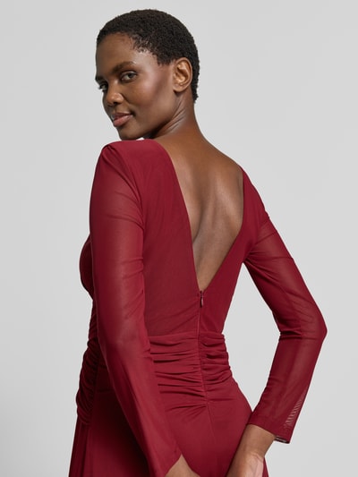 Modelka nosi 'Abendkleid mit tiefem Rückenausschnitt und Raffungen' od TROYDEN COLLECTION, bordowy szyfon, krój slim fit, okrągły dekolt, dekolt z wycięciem typu łezka, półprzezroczyste rękawy, marszczenia, głęboki dekolt na plecach, zamek z tyłu, długość tyłu w rozmiarze 36: 152 cm, szerokość w rozmiarze 36: 36 cm, długość rękawa w rozmiarze 36: 58 cm, widok na plecy z przodu