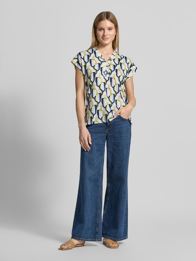 Vrouwenmodel draagt Blusenshirt uit katoen- en viscosemix model 'FELICITY' van Soyaconcept, recht model, V-hals, ruglengte maat S 64 cm, mouwlengte maat S 10 cm, veelkleurig geometrisch patroon, gladde textuur, rechte broek, Ganzkörperansicht van voren.