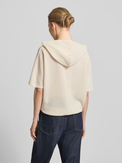 Frauenmodel trägt Strickshirt mit Kapuze Modell 'Gikaria' von OPUS im Relaxed-Fit aus Material-Mix mit Baumwoll-Anteil, Strukturmuster, Farbe Beige, Rückenlänge 56 cm bei Größe 36, Ärmellänge 26 cm, Ganzkörperansicht Rückansicht.