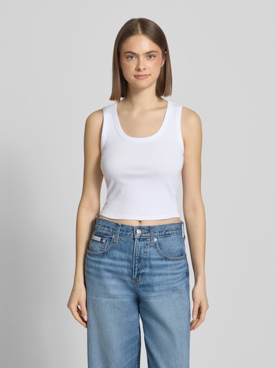 Vrouwenmodel draagt Slim Fit Tank Top uit katoenmix model 'EASY' van Only, effen wit, fijnribstructuur, brede bandjes, u-hals, full body vooraanzicht.