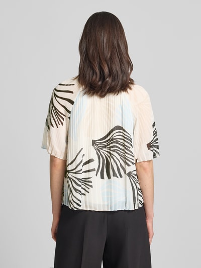 Frauenmodel trägt Regular Fit Blusenshirt in Plissee-Optik von s.Oliver BLACK LABEL, delikat plisowana struktura, wzór allover, krótki rękaw, rüschenkragen, zapięcie na troczek, widoczne czarno-beżowe liście na jasnym tle, tył, Ganzkörperansicht Rückansicht.