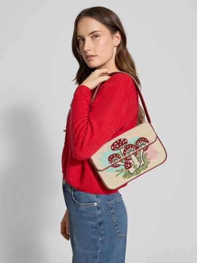 Frauenmodel trägt Handtasche mit Ziersteinbesatz Modell 'Tommy' von Staud in floralem Design, Überschlag, Schulterriemen, Nahaufnahme Oberkörper.
