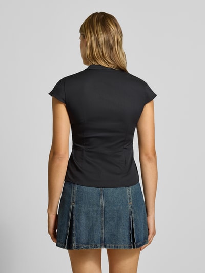 Frauenmodel trägt Slim Fit T-Shirt aus Baumwoll-Mix von Gina Tricot, kurzer Ärmel, Stehkragen, V-Ausschnitt, dunkel, Ganzkörperansicht Rückansicht.