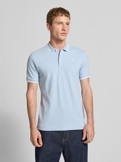 Männermodel trägt Slim Fit Poloshirt mit Logo-Stitching Modell 'Dunda' von G-Star Raw aus elastischem Baumwoll-Mix, Ganzkörperansicht von vorne.