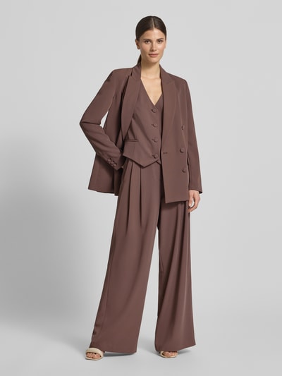 Modelka kobieca nosi Regular Fit Weste mit V-Ausschnitt von Christian Berg Cocktail, elastyczna mieszanka materiałów, krój regular fit, dekolt w serek, listwa guzikowa na całej długości, długość tyłu w rozmiarze 36 to 46 cm, kolor brązowy, gładka tekstura, szerokie nogawki, pełny garnitur; widok całej sylwetki z przodu