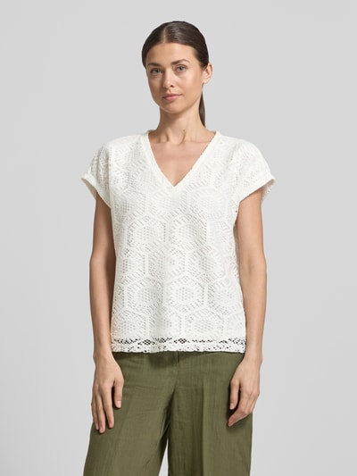 Kobiece model prezentuje damski t-shirt Boxy Fit T-Shirt mit semitransparentem Besatz Modell 'IRIS' od Vero Moda, efekt: jednolity kolor, wzór: abstrakcyjny, półprzezroczysty materiał jako obszycie, dekolt w serek, bez rękawów, wykończenie materiału: ażur, krój stretch, całkowity widok z przodu.