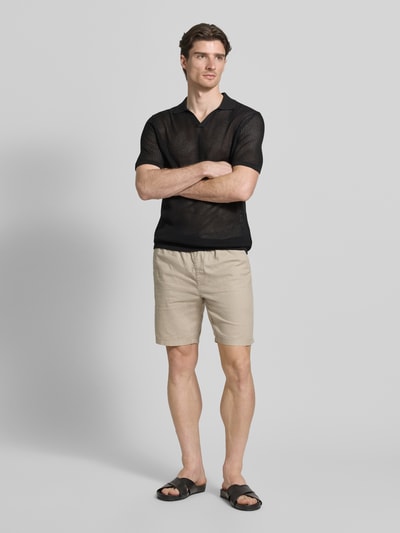 Männermodel trägt Slim Fit Poloshirt mit V-Ausschnitt von Antony Morato aus Baumwoll-Modal-Mix, schwarz, Halbarm, Ganzkörperansicht von vorne. Rückenlänge bei Größe M: 75 cm.