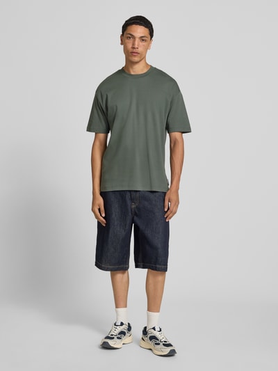 Männermodel trägt Relaxed Fit T-Shirt aus reiner Baumwolle von Marc O'Polo Denim in Khaki, Herren T-Shirt, einfarbig, Ganzkörperansicht von vorne.