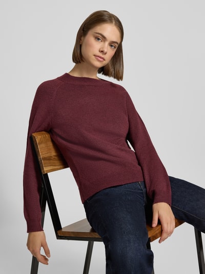 Frauenmodel trägt Regular Fit Pullover mit Rundhalsausschnitt Modell 'RICA' von ONLY in Dunkelrot, glatte Strickstruktur, Nahaufnahme Oberkörper, Damen Pullover von ONLY.
