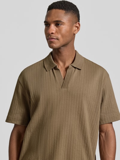 Männermodel trägt Relaxed Fit Poloshirt aus reiner Baumwolle von Marc O'Polo, unifarben, strukturierte Webstruktur, Nahaufnahme Oberkörper.