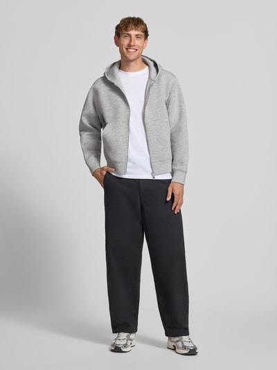 Männermodel trägt Relaxed Fit Sweatjacke mit Zweiwege-Reißverschluss von JACK & JONES, grau, Känguru-Tasche, Ganzkörperansicht von vorne.