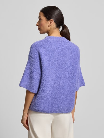 Modelka kobieca nosi Strickpullover mit gerippten Abschlüssen Modell 'ZOLLY' od American Vintage, fioletowy melanż, luźny krój, dzianina z wełną i alpaką, półkrótkie rękawy, okrągły dekolt, widok na całą sylwetkę z tyłu.
