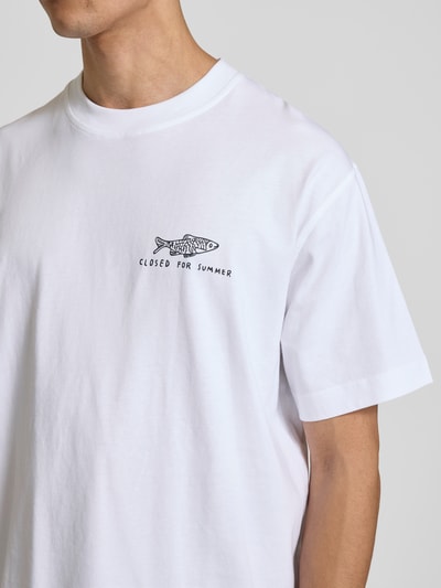 Männermodel trägt Regular Fit T-Shirt mit Statement-Print von Closed in Weiß aus reiner Baumwolle, Rundhalsausschnitt, Kurzärmelig, Nahaufnahme Oberkörper.