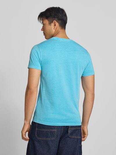 Männermodel trägt T-Shirt mit Rundhalsausschnitt und Label-Stitching von Superdry in Hellblau, reine Baumwolle, Rückenlänge 66 cm, Ganzkörperansicht Rückansicht.