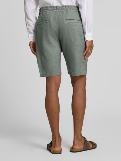 Männermodel trägt Tapered Chinoshorts aus Leinen-Mix Modell 'DS_3S' von BOSS Orange in Hellgrün, Leinenstruktur, Paspeltaschen, Ganzkörperansicht Rückansicht.