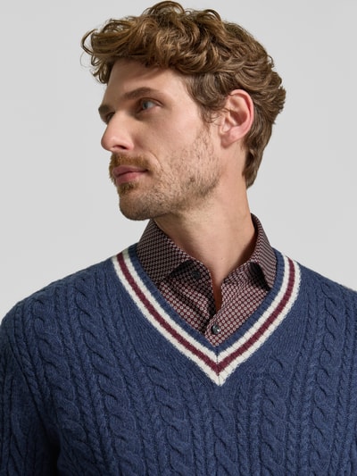 Männermodel trägt Strickpullover mit Woll-Anteil von MCNEAL, Zopfmuster, V-Ausschnitt, blau-weiß, Nahaufnahme Oberkörper, Woll-Mix
