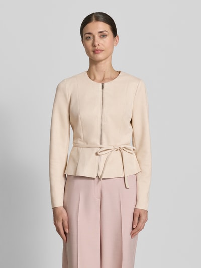 Frauenmodel trägt Blazer mit Reißverschluss und Bindegürtel von Zero in Beige, Material-Mix mit Stretch-Anteil, taillierter Schnitt, Rundhalsausschnitt, Reißverschluss, Bindegürtel, Rückenlänge 50 cm, Brustweite 44 cm, Ärmellänge 61 cm, Ganzkörperansicht von vorne.