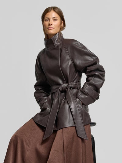 Vrouwenmodel draagt Lederjacke aus echtem Leder van MYON in donkerbruin lamsnappa, getailleerde pasvorm met reverskraag en tailleband, ruglengte maat 36: 74 cm, schouderbreedte: 50 cm, borstwijdte: 42 cm, mouwlengte: 65 cm, detailopname bovenlichaam.