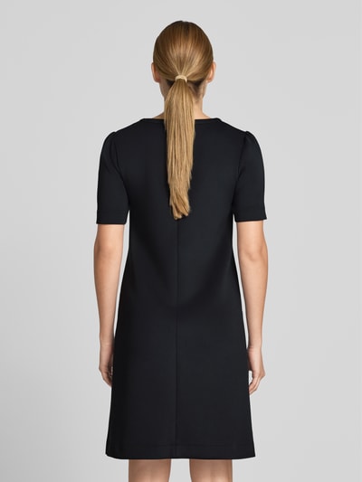 Frauenmodel trägt Knielanges Kleid mit seitlichen Eingrifftaschen von Marc Cain, Schwarz, Material-Mix mit Stretch-Anteil, A-Linie, Rückansicht.