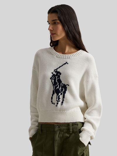 Frauenmodel trägt Regular Fit Strickpullover aus reiner Baumwolle von Polo Ralph Lauren in Two-Tone-Optik, Pony-Intarsia, Crew Neck, langarm, gerippte Abschlüsse, Ganzkörperansicht von vorne.