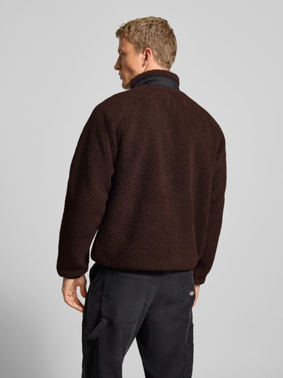 Männermodel trägt Fleecejacke mit Brusttasche Modell 'PRENTIS LINER' von Carhartt Work In Progress, braun, strukturierte Textur, Ganzkörperansicht Rückansicht.