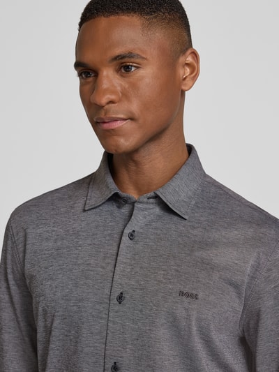 Männermodel trägt Slim Fit Freizeithemd aus reiner Baumwolle Modell 'MYSOFT_2' von BOSS Orange, unifarben, melange, Nahaufnahme Oberkörper.