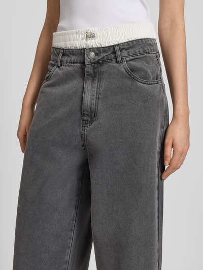 Frauenmodel trägt Relaxed Fit Jeans im Boxer-Look von Karo Kauer, grau, Baumwoll-Viskose-Mix, Label-Detail, Nahaufnahme Oberkörper.