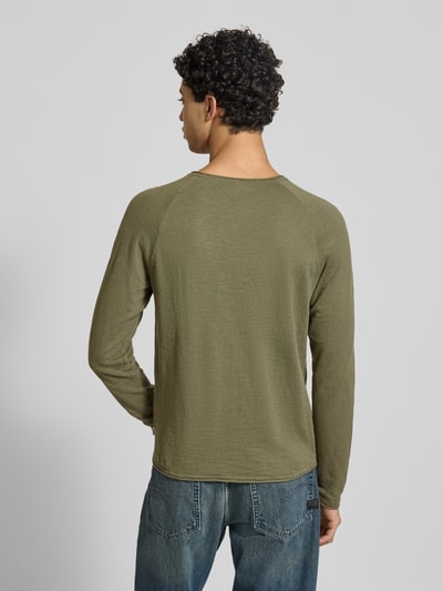 Männermodel trägt Regular Fit Longsleeve mit Logo-Patch Modell 'Breeze' von JACK & JONES aus reiner Baumwolle, Strick-Optik, Olivgrün, Rundhalsausschnitt, Rückansicht Ganzkörperansicht.