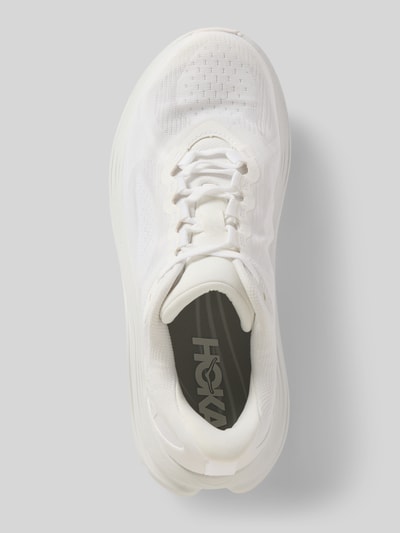 Produktfoto, sneakersy z detalem z logo, model 'Kawana' od HOKA, biały kolor, wyprofilowana profilowana podeszwa, krój zaokrąglony, wiązanie, wysokość obcasa w rozmiarze 40: 4 cm, wysokość cholewki w rozmiarze 40: 6 cm, szerokość w rozmiarze 40: 10 cm