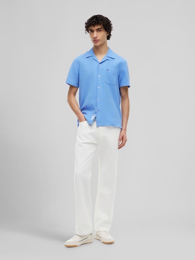 Männermodel trägt Regular Fit Freizeithemd aus Leinen-Baumwoll-Mix von Tommy Jeans in Optik: Unifarben, Flammgarn, Ganzkörperansicht von vorne.