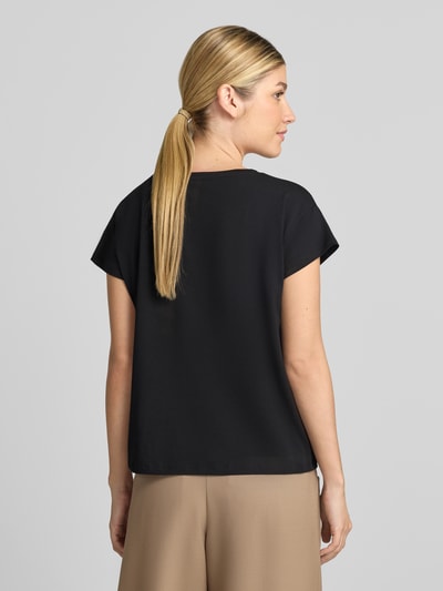 Frauenmodel trägt Regular Fit T-Shirt aus Baumwoll-Modal-Mix von MORE & MORE in Schwarz, glatte Textur, Ganzkörperansicht Rückansicht.
