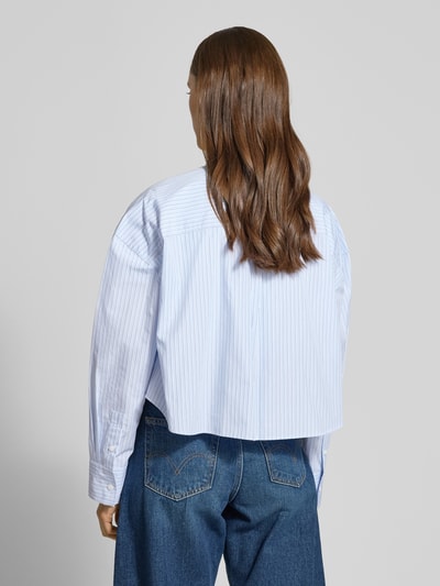 Vrouwenmodel draagt 'Cropped Bluse mit Brusttasche und Label-Stitching' van Calvin Klein Jeans in lichtblauw met fijne strepen, zuivere katoen, cropped fit, hemdkraag, borstzak en label-stitching, ruglengte 51 cm, mouwlengte 53 cm, geheel achteraanzicht.