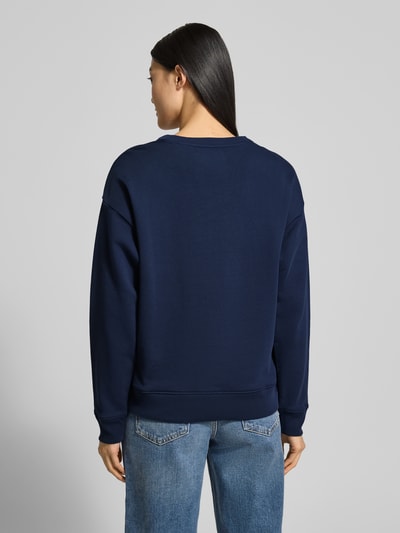 Frauenmodel trägt Sweatshirt mit Label-Print und Rundhalsausschnitt von Gant, Reine Baumwolle, Relaxed-Fit, Dunkelblau, Ganzkörperansicht Rückansicht.
