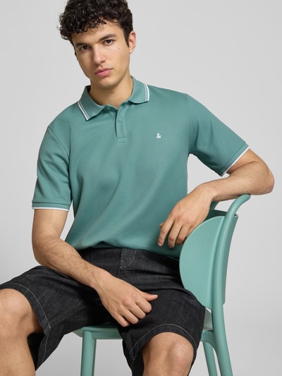 Männermodel trägt Regular Fit Poloshirt mit Strukturmuster Modell 'AUSTIN' von Jack & Jones, Material-Mix, Knopfleiste, Stitching, Nahaufnahme Oberkörper. Rückenlänge bei Größe M: 69 cm.