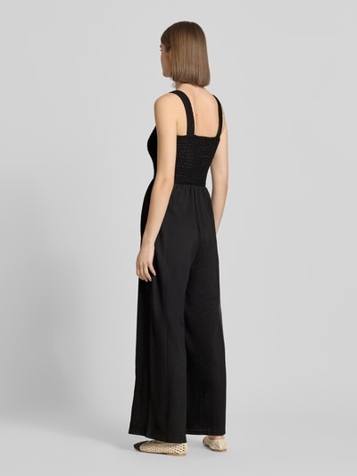 Frauenmodel trägt Regular Fit Jumpsuit mit gesmoktem Rumpf Modell 'ELISE' von Only, unifarben, breite Träger, Rückansicht, Ganzkörperansicht.