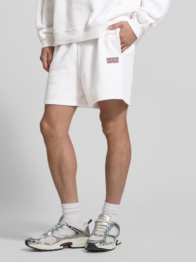 Männermodel trägt Shorts mit Logo Modell 'PLIZZY' von American Vintage aus Reine Baumwolle, Relaxed-Fit, Weiß, Nahaufnahme Oberschenkel.