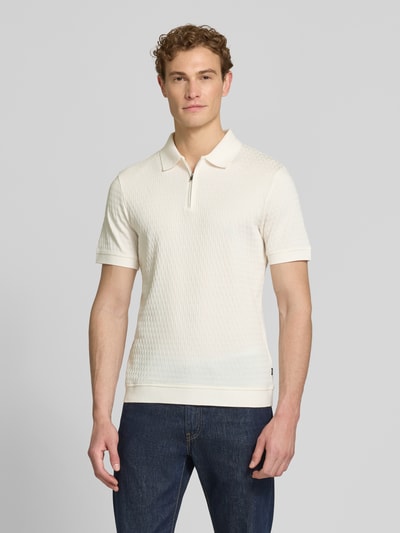 Männermodel trägt Slim Fit Poloshirt mit Reißverschluss Modell 'Franciscojose' von JOOP! Collection aus Reiner Baumwolle in Weiß, Ganzkörperansicht von vorne. Rückenlänge bei Größe M: 70 cm.
