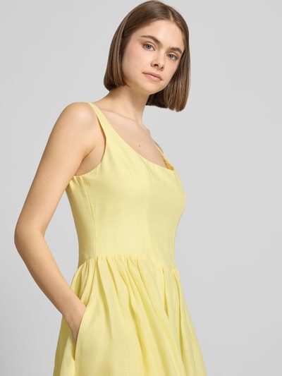 Frauenmodel trägt Midikleid aus Ramie Modell 'LAWRENCE SCOOP' von Bardot, A-Linie, Karree-Ausschnitt, Nahaufnahme Oberkörper. Rückenlänge bei Größe 36: 114 cm, Brustweite bei Größe 36: 43 cm, Reißverschluss hinten, zartes Gelb, feine Textur.