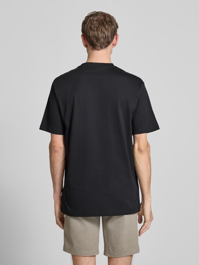Männermodel trägt Relaxed Fit T-Shirt aus reiner Baumwolle Modell 'FRED LIFE' von Only & Sons, unifarben, Ganzkörperansicht Rückansicht.