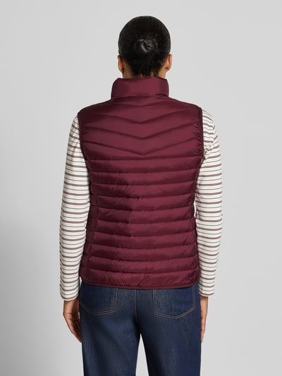 Vrouwenmodel draagt bodywarmer in stiksels van FUCHS SCHMITT, getailleerd, opstaande kraag, tweewegritssluiting, ruglengte maat 36: 55 cm, schouderbreedte maat 36: 39 cm, borstwijdte maat 36: 48 cm, bordeauxrood, gladde textuur, volledige achteraanzicht