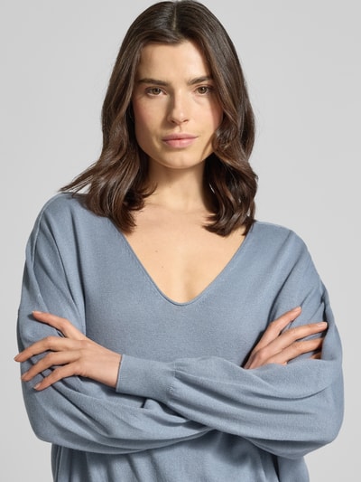 Modelka kobieta nosi Strickpullover aus Baumwoll-Kaschmir-Mix Modell 'RISORY' od Drykorn, kolor niebieskoszary, krój relaxed fit, dekolt V, długość pleców w rozmiarze S: 53 cm, długość rękawa w rozmiarze S: 48 cm, tkanina miękka, gładka, zdjęcie: zbliżenie górnej części ciała.